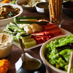 a table topped with plates of vegetables and dip at Gaia Retreat Center in Ubud