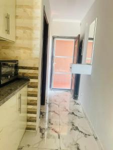 a kitchen with a marble floor and a window at Porto marina Panoramica sea view in front marina 2 in El Alamein +11 photos