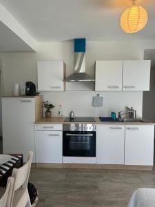 a kitchen with white cabinets and a black oven at Ganzes Haus in Basel Leymen Tiere willkommen in Leymen