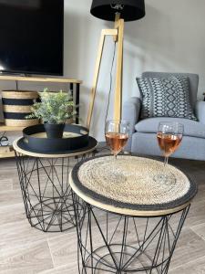 two tables with wine glasses on them in a living room at Logement 5 pers pied de piste dans résidence Odalys in Valmeinier