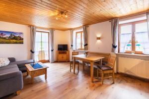 un salon avec un canapé et une table dans l'établissement Aschenauer Hof, à Ruhpolding