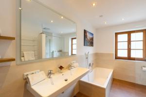 une salle de bain avec un lavabo et un grand miroir dans l'établissement Aschenauer Hof, à Ruhpolding 45 autres photos