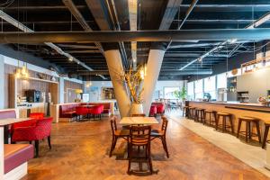 a restaurant with wooden tables and chairs and a bar at Antwerp Harbour Hotel in Antwerp
