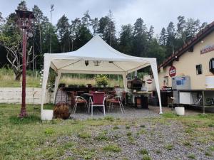a white tent with tables and chairs in a yard at l'Adapté in Raon-lʼÉtape