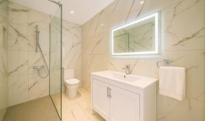 ein Badezimmer mit Toilette, Waschbecken und Dusche in der Unterkunft HiddenGems Residences 202 - The LXR Penthouse - Pool & Beach Steps in Paphos City