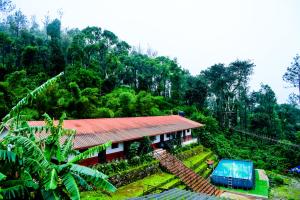 a small house in the middle of a forest at Kumbles Misty Mount in Attigundi