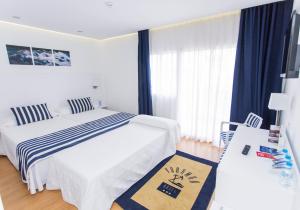 a bedroom with a bed and a table with a desk at Hotel Voramar in Benidorm