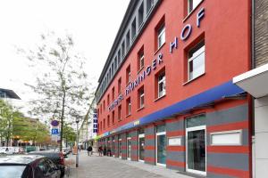 a red building with a sign on the side of it at Cityhotel Thüringer Hof Design Hannover - Self Check-In in Hannover