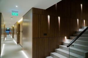 a hallway with stairs in a building with a exit sign at ICON City Hotel Samarinda in Samarinda