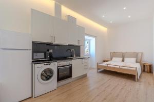 a kitchen with a washer and dryer in a room at Downtown Studio Apartment G - 150m from the Beach in Albufeira