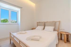 a bedroom with a large bed with two towels on it at Downtown Studio Apartment G - 150m from the Beach in Albufeira