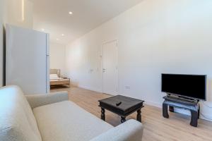 a living room with a couch and a flat screen tv at Downtown Studio Apartment G - 150m from the Beach in Albufeira