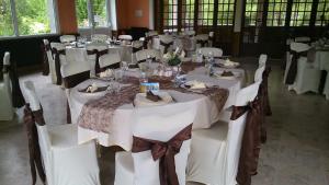 a large dining room with white tables and chairs at Chambres d'Hôtes du Moulin du Vey in Clécy