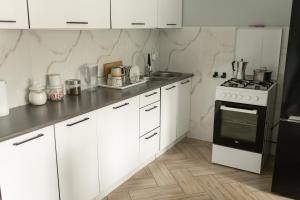 a kitchen with white cabinets and a stove top oven at Agroturystyka Za Dębem in Łagów