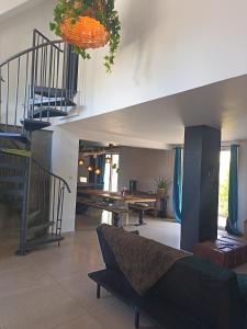 sala de estar con escalera y mesa en Villa événements Balnéo & Spa, en Villampuy