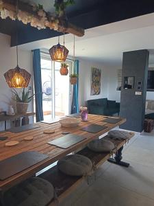 Un comedor con mesa y sillas de madera. en Villa événements Balnéo & Spa, en Villampuy 13 fotos más