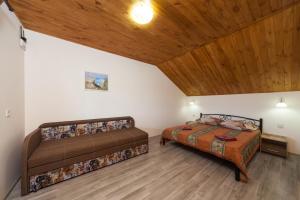 two beds in a room with a wooden ceiling at Panorama in Vapnyarka