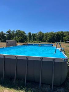 a large swimming pool in a field at Comme chez Moi - Mobile-home dans camping à la ferme in Arcomps