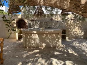 a stone patio with a table and a bench at Dar Younes in Houmt Souk