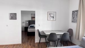 a dining room with a table and chairs and a bedroom at DE Apartment in Neu-Ulm