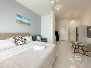 ein Schlafzimmer mit einem großen weißen Bett und einem Tisch in der Unterkunft SKS Pavilion Town House By MWM Johor Bahru in Johor Bahru + 85 Fotos