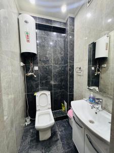 une salle de bain avec des toilettes blanches et un lavabo dans l'établissement Простор, комфорт и уют!, à Bishkek