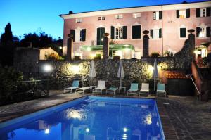 a villa with a swimming pool in front of a building at Villa Lorien in Massarosa