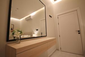 baño con espejo grande y jarrón con flores en luxury apartment - COZY apt, en Riad