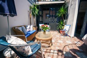 a patio with chairs and a table with flowers on it at Dar Rania in Tangier