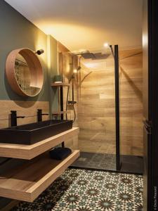 a bathroom with a black sink and a mirror at Ti Ana Chambre Bohème in Évran