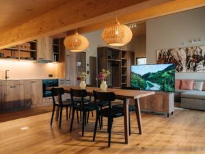 a kitchen and dining room with a wooden table and chairs at KURVE Apartments & Lounge in Adelboden