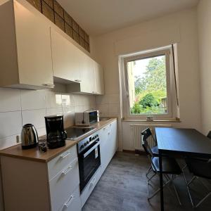 a kitchen with white cabinets and a table and a window at WDI - WokersDream in Krefeld
