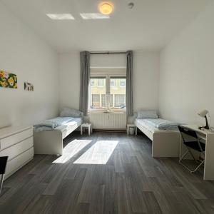 a room with two beds and a desk and a window at WDI - WokersDream in Krefeld