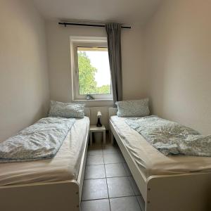 two twin beds in a room with a window at WDI - WorkersDream 2 in Krefeld