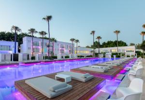 a pool with white lounge chairs and a swimming pool at So White Beach Resort in Ayia Napa