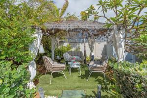 a garden with a gazebo with chairs and a table at Heaven Ocin vacacional in Telde