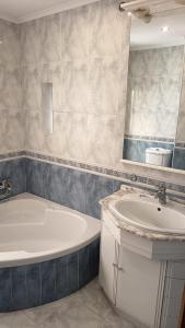 a bathroom with a tub and a sink and a mirror at Casa Anita - Apartamento em Sobreda - Charneca da Caparica in Sobreda