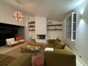 a living room with a couch and a table at Chambre d'hôtes Hôte des Portes Île de Ré in Les Portes
