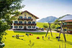un groupe de personnes jouant sur une aire de jeux en face d'un bâtiment dans l'établissement Aschenauer Hof, à Ruhpolding