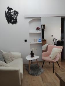 a living room with a couch and a table and a chair at Apartment romantyczny SAKURA in Jędrzejów