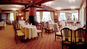 ein Festsaal mit Tischen und Stühlen mit weißen Tischdecken in der Unterkunft Indiana Hotel in Iaşi