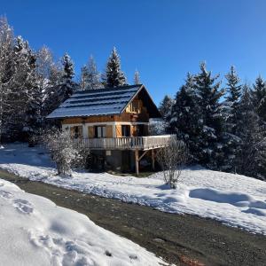 Una cabaña de troncos en el bosque en la nieve en La Lézardière - Chalet spacieux près des pistes, en La Toussuire