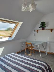 una camera da letto con un letto, una scrivania e una finestra di Maison 12 pers Douarnenez kerlaz 2 étoiles Atout France a Kerlaz