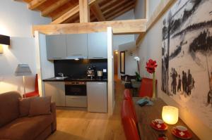 een woonkamer met een bank en een keuken bij L'Epicerie Du Monal in Sainte-Foy-Tarentaise