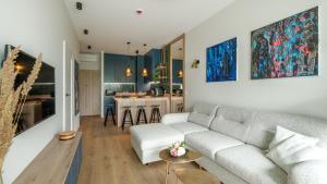 un salon avec un canapé et une cuisine dans l'établissement Omega Lake, Sun & Snow, à Olsztyn