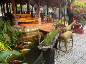 An Hoa 2 : حديقة بها بركة سمك مع تمثالين للغزلان