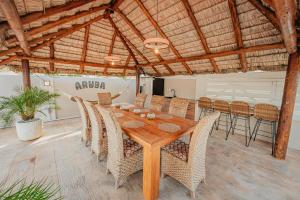 a dining room with a wooden table and chairs at Villa de Leon suitable for 14 persons. 5 bedrooms 5 bathrooms in Palm-Eagle Beach