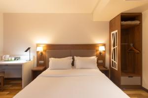 a bedroom with a large white bed and a desk at Campanile PRIME - Metz Centre Gare in Metz +38 photos