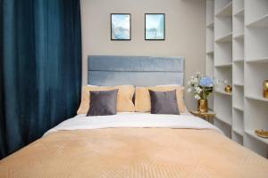 a bedroom with a large bed with blue curtains at Arbat Central Apartment in Almaty