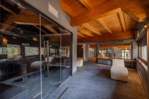 a living room with glass walls and wooden ceilings at Alchimia WellResort in Comano Terme